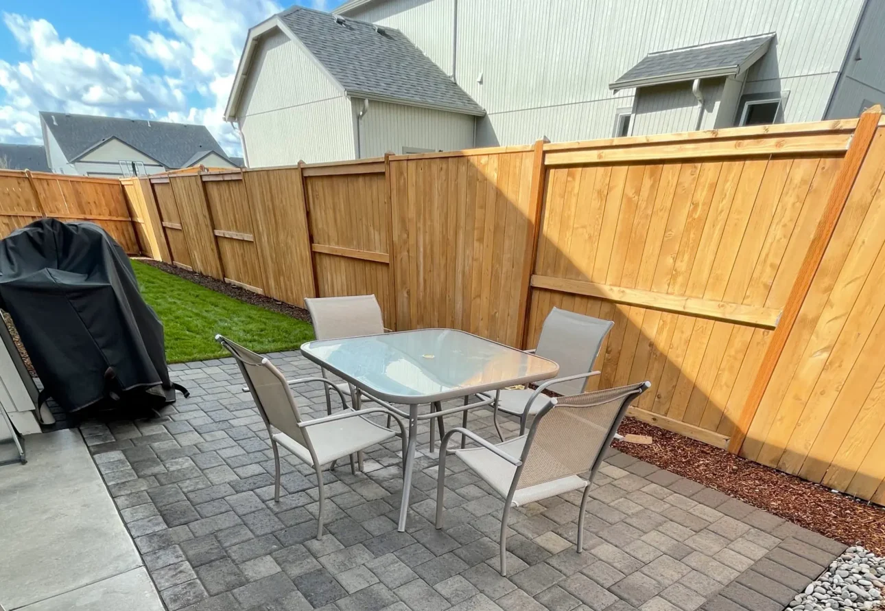 Custom paver patio installation with contrasting border stones and outdoor seating area