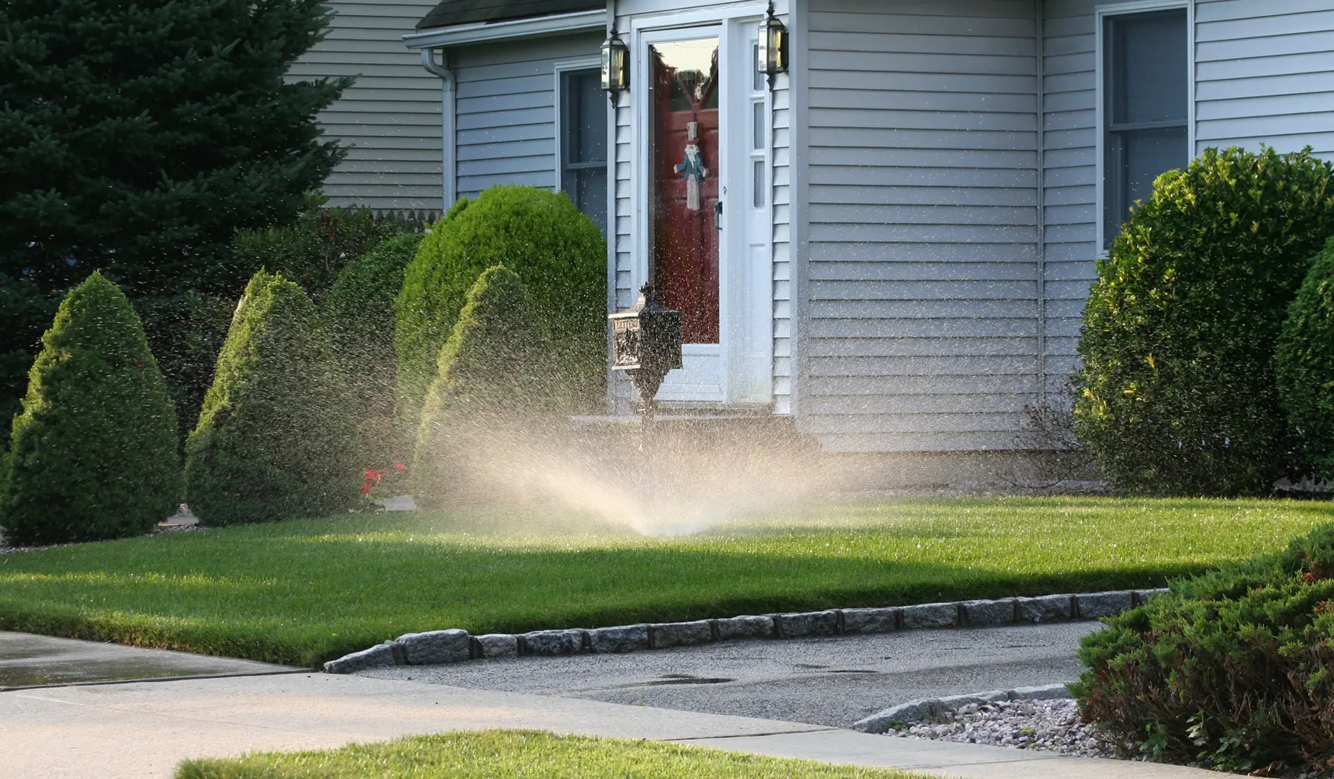 Residential lawn irrigation system watering front yard landscaping